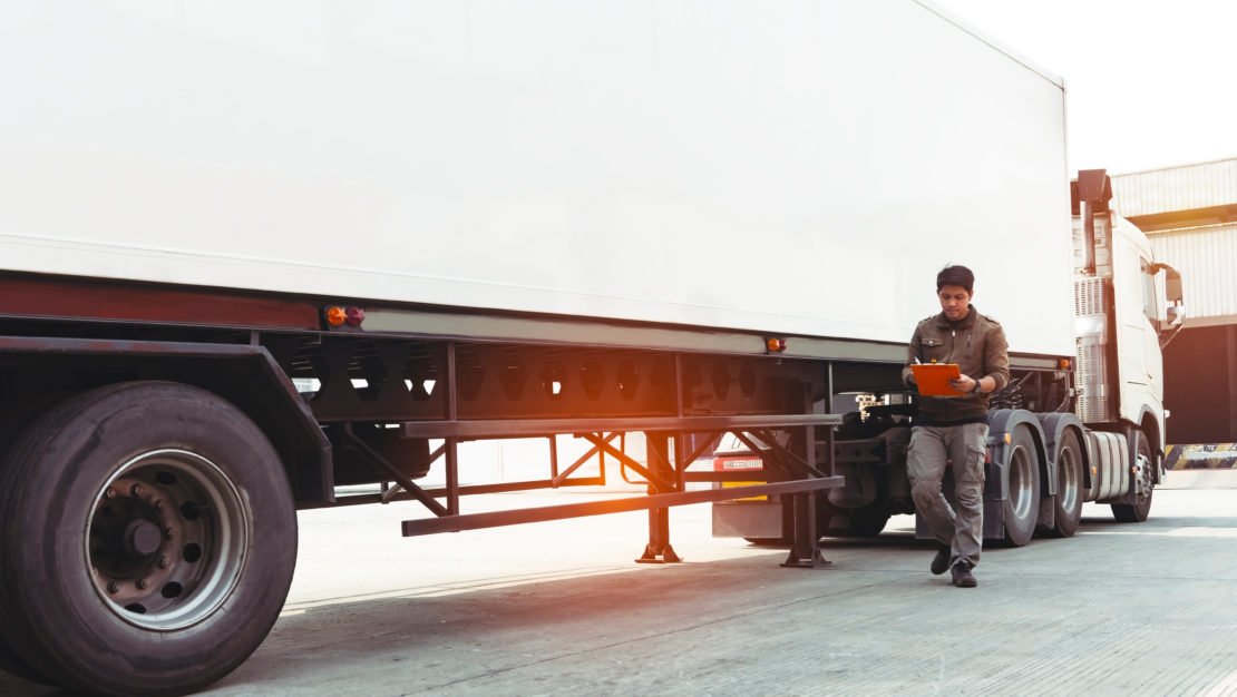 Truck driver holding clipboard inspecting safety vehicle m