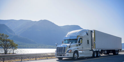 Semi Truck on Road with Mountain Background
