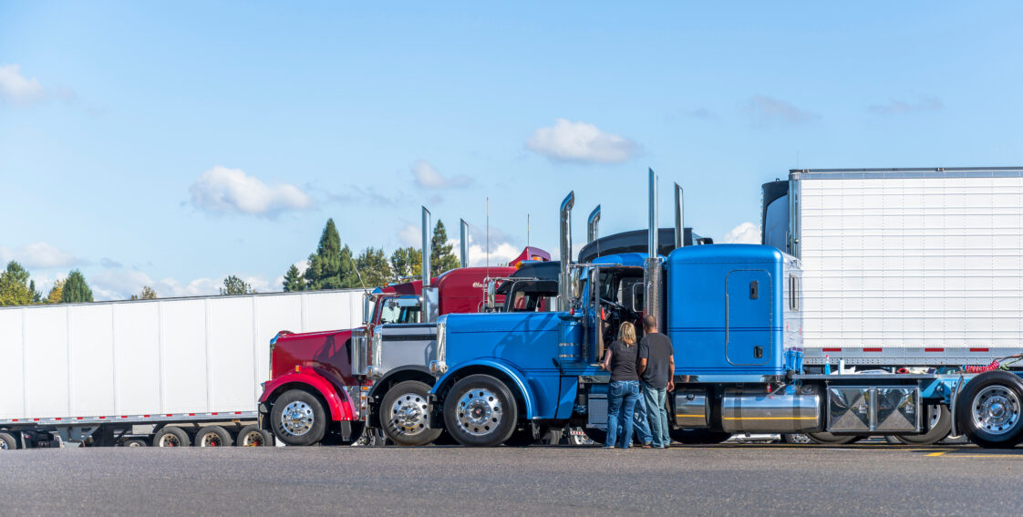 Truck Drivers Standing in front of Semi Trucks