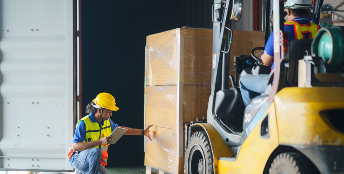 forklift driver loading a shipping cargo container